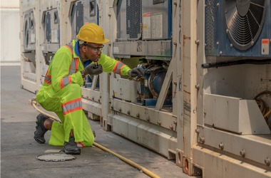 A tech is seen diagnosing a problem. Merit Mechanical offers commercial refrigeration repair in Galesburg IL.