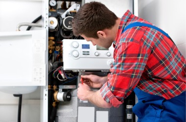 A tech is seen working on a boiler. Merit Mechanical offers mechanical services.