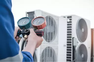 An HVAC tech is seen performing service on a unit. Merit Mechanical performs commercial AC service. 