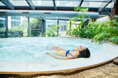 A woman relaxes in an indoor pool. Merit Mechanical offers Pool Dehumidification in Chillicothe IL.