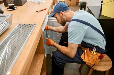 A technician is seen working on a commercial refrigerator. Merit Mechanical provides Commercial Refrigeration Repair in Chillicothe IL.