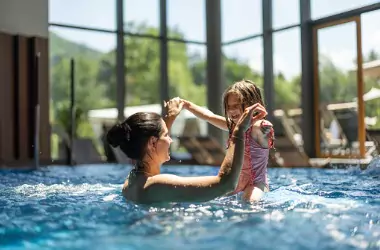 A mother and daughter play in an indoor pool. Merit Mechanical offers Pool Dehumidification in Chillicothe IL.